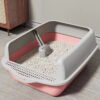 Modern pink and gray cat litter box with scoop, stylish home interior, clean cat essentials