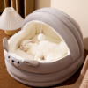 White cat sleeping in a cozy gray plush cat bed with a cute bear design and hanging ball toy