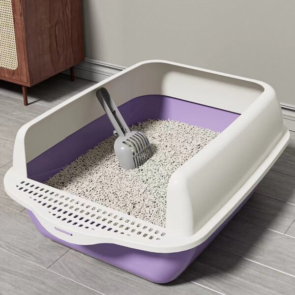 Large purple and white cat litter box with scoop, filled with clean cat litter, on tiled floor