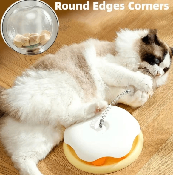 Cat playing with interactive treat dispenser toy on wooden floor, closeup of round edges design