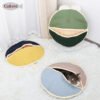 d118c24c4ba0af5db4c8d6d1b575 Cozy round cat beds in assorted colors, one with a cat inside, on a white rug.