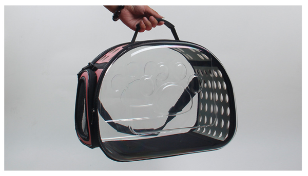 Clear window cat carrier bag with paw print design and ventilation holes, hand-held