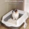Large fluffy cat sitting in a spacious open litter box with scoop, indoor pet essentials.